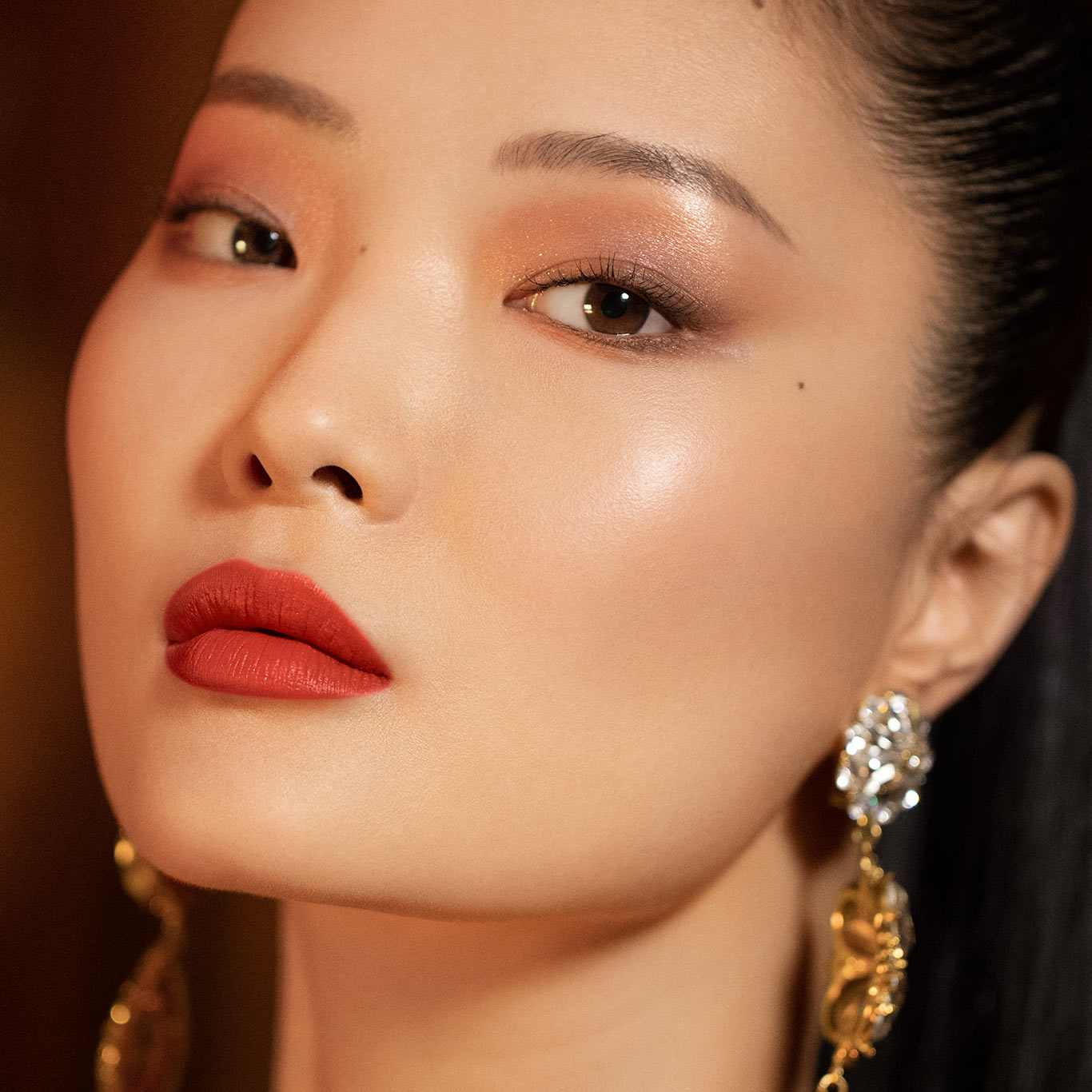 Woman with glowing eyeshadow and makeup with a red lipstick