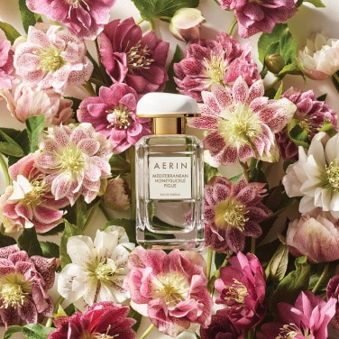 AERIN Rose Cocoa Perfume surrounded by pink roses